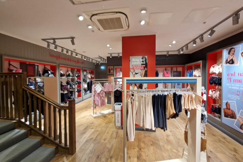 Interior of a Bravissimo store with various lingerie on rails and new ceiling lighting